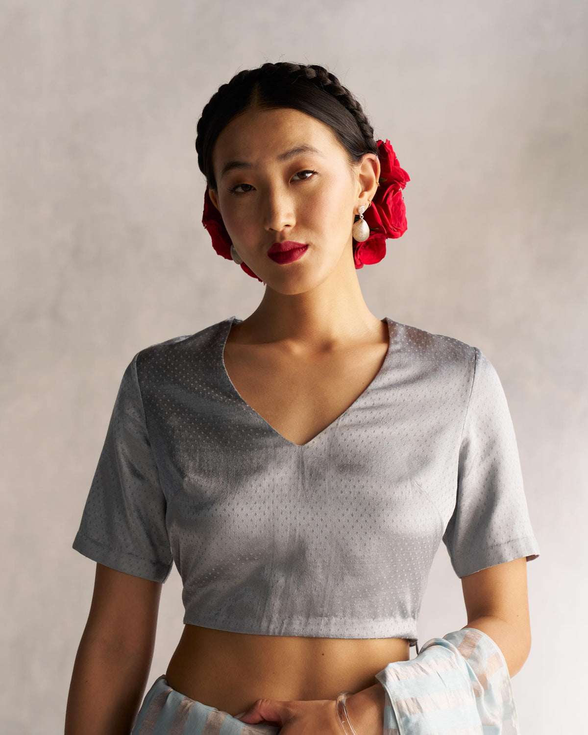 Person wearing a grey Celestial Blouse with a V-neck and dotted texture.