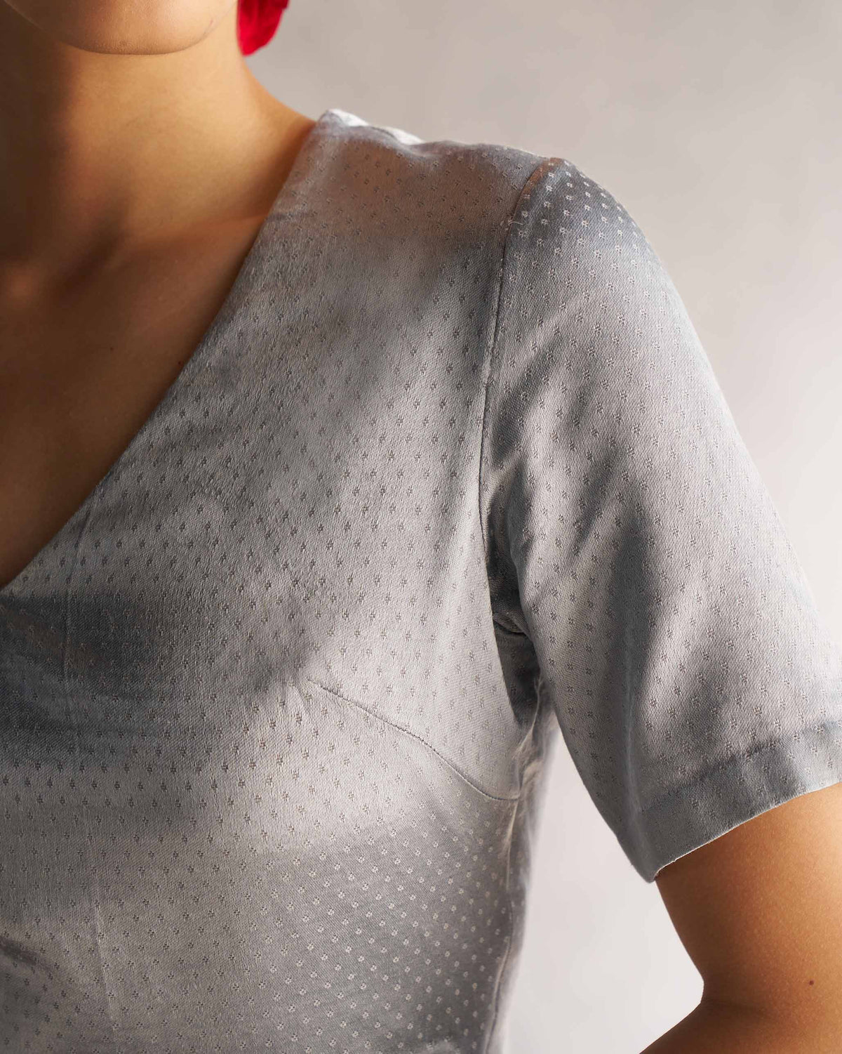 Close-up of grey Celestial Blouse showing the V-neck and tiny dot weave.