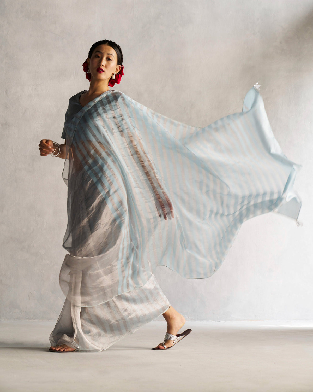 Full-length view of a Celestial Blouse styled with a sheer striped drape worn by a person.