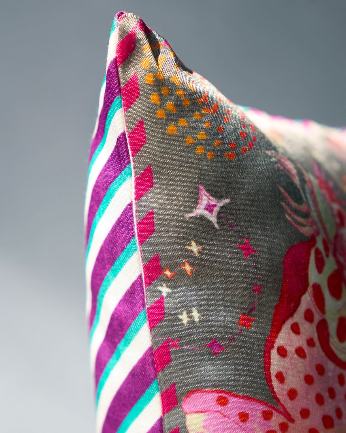 Close-up of the Barong Cushion Cover showing its striped edge and pink print.