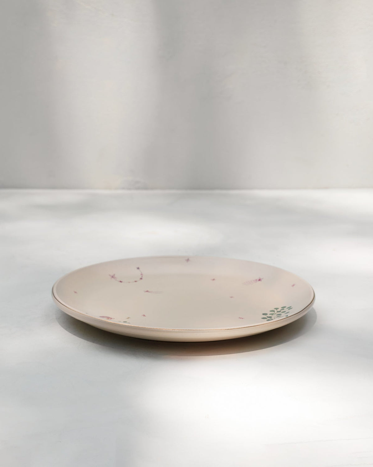 Side view of the Barong Dinner Plate with its thin gold rim.