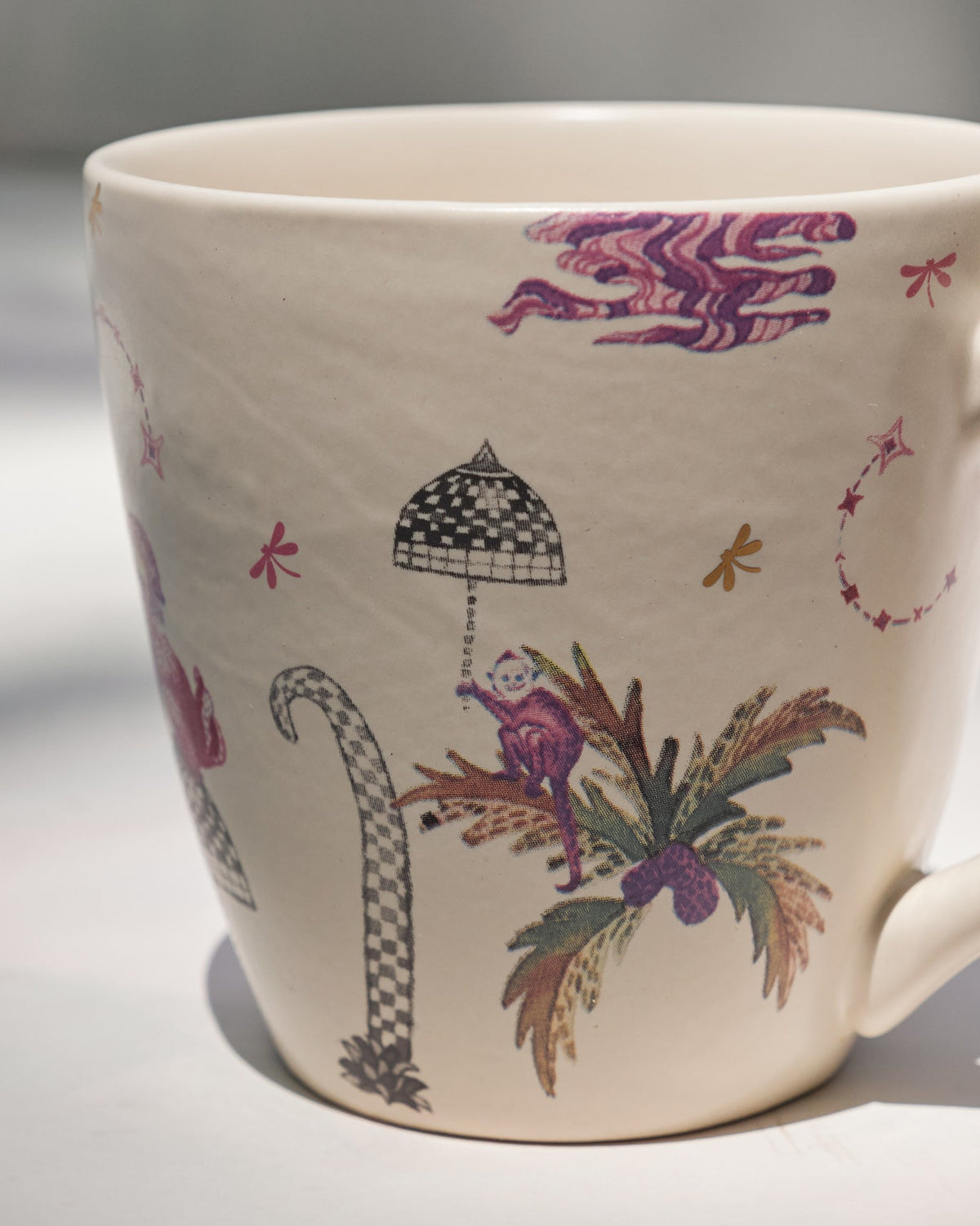 Close-up of the Barong Conical Mug showing a palm tree and checkered parasol motif.