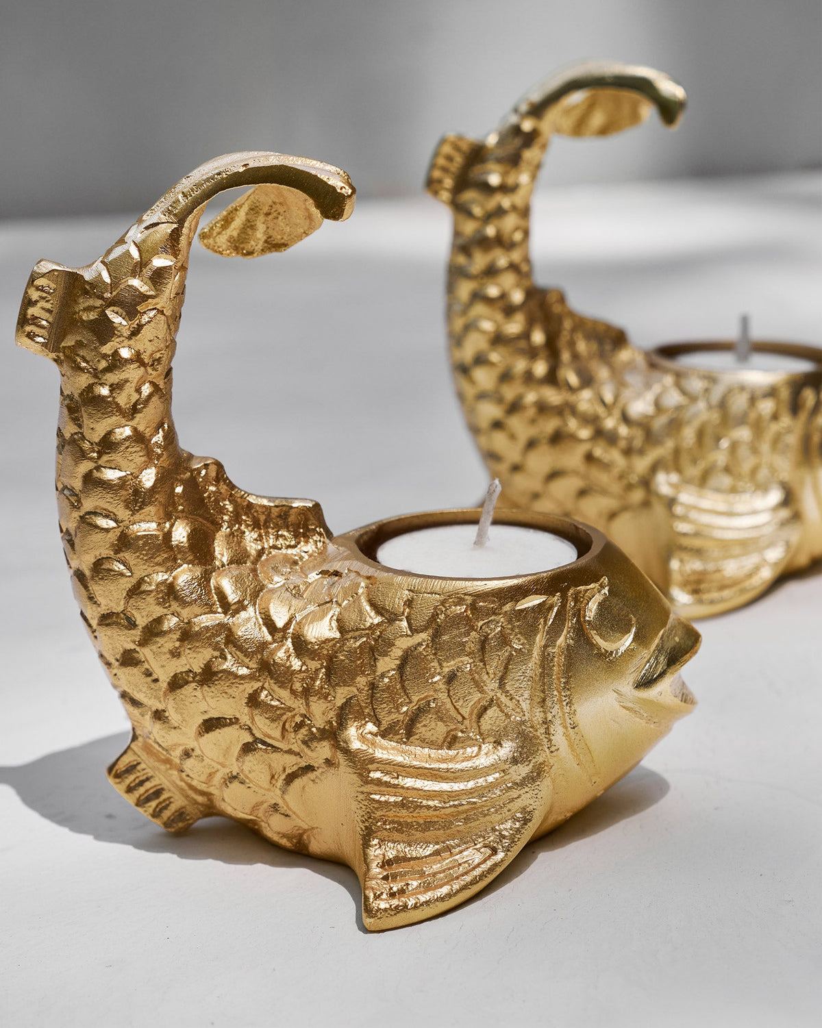 Close-up of Dory Tea Light Holder, a gold fish with a tea light.