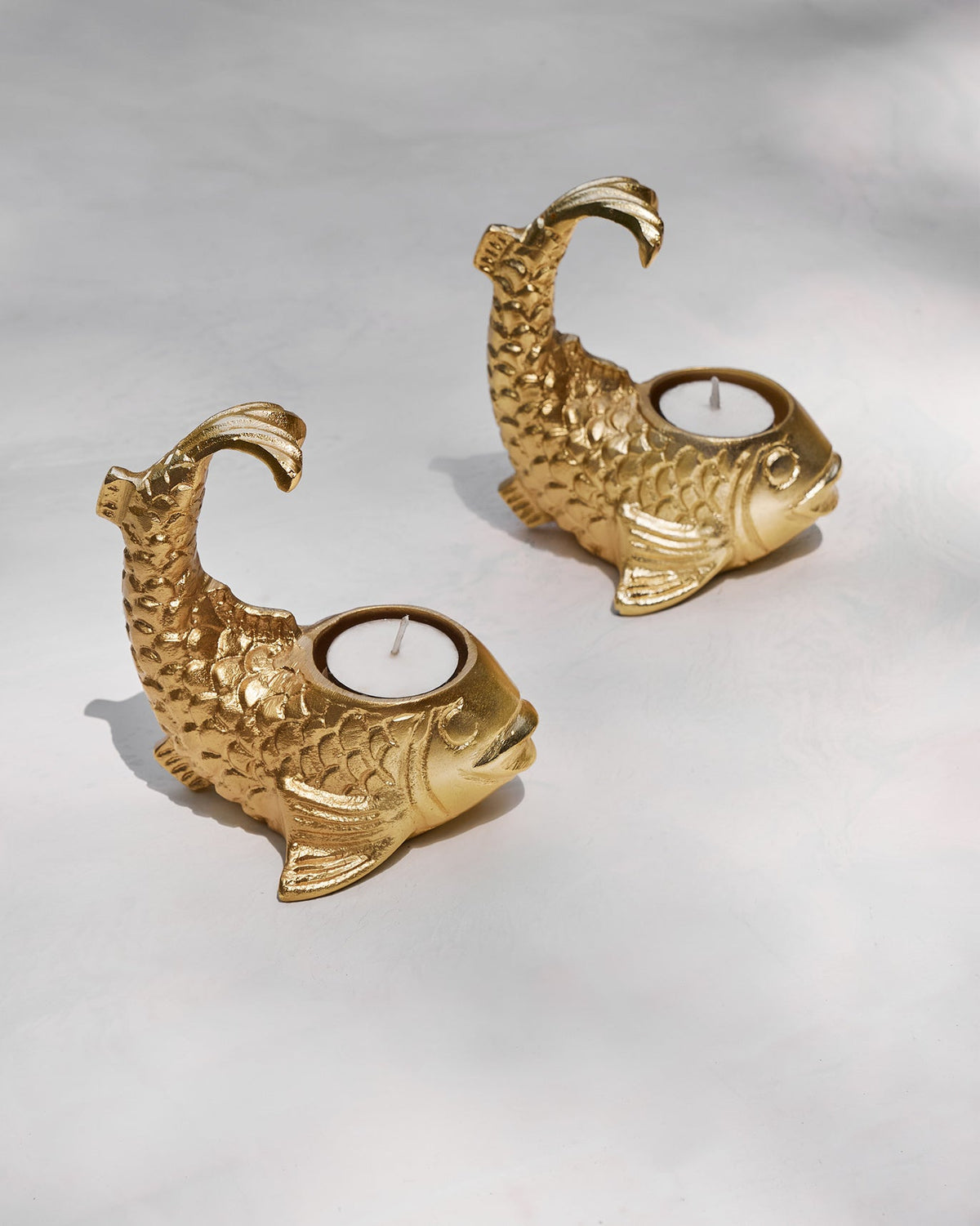 Dory Tea Light Holders shaped like gold fish, angled to show their tea light cups.