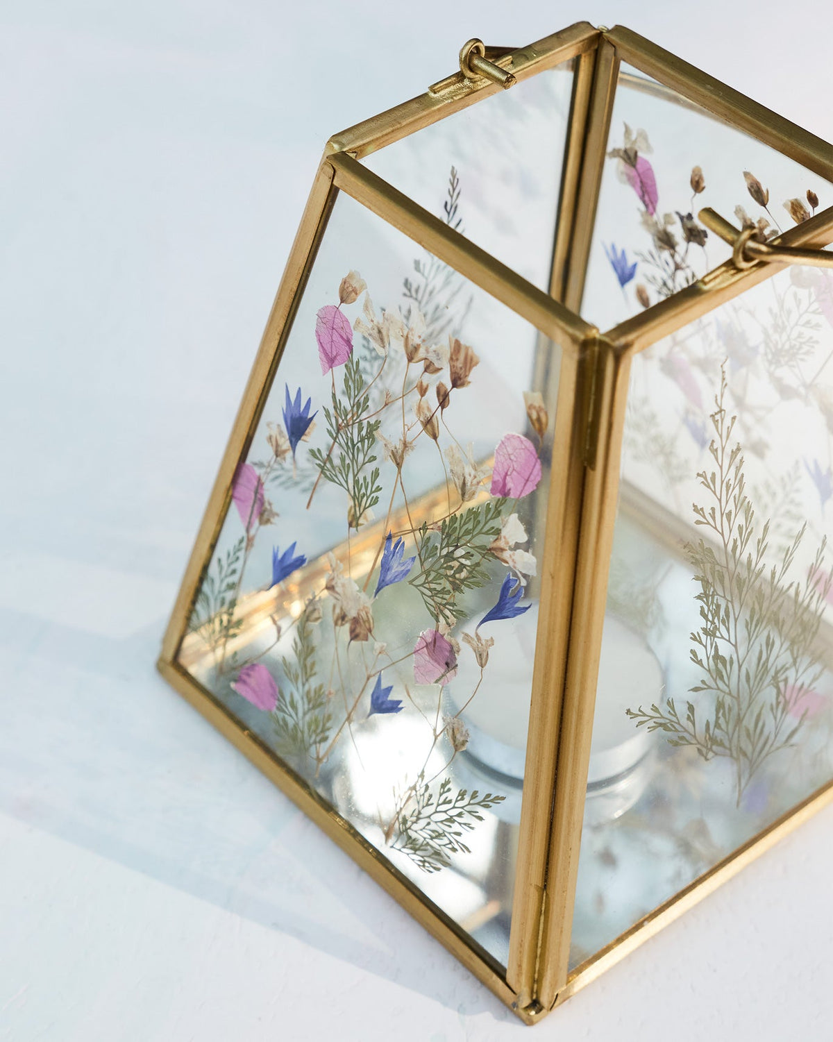 Angled view of the Patio Lantern showing pressed flowers through its glass panels.