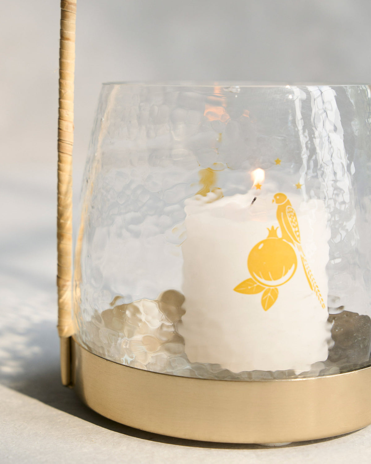 Close-up of a Vesak Lantern showing its textured glass shade and brass base.