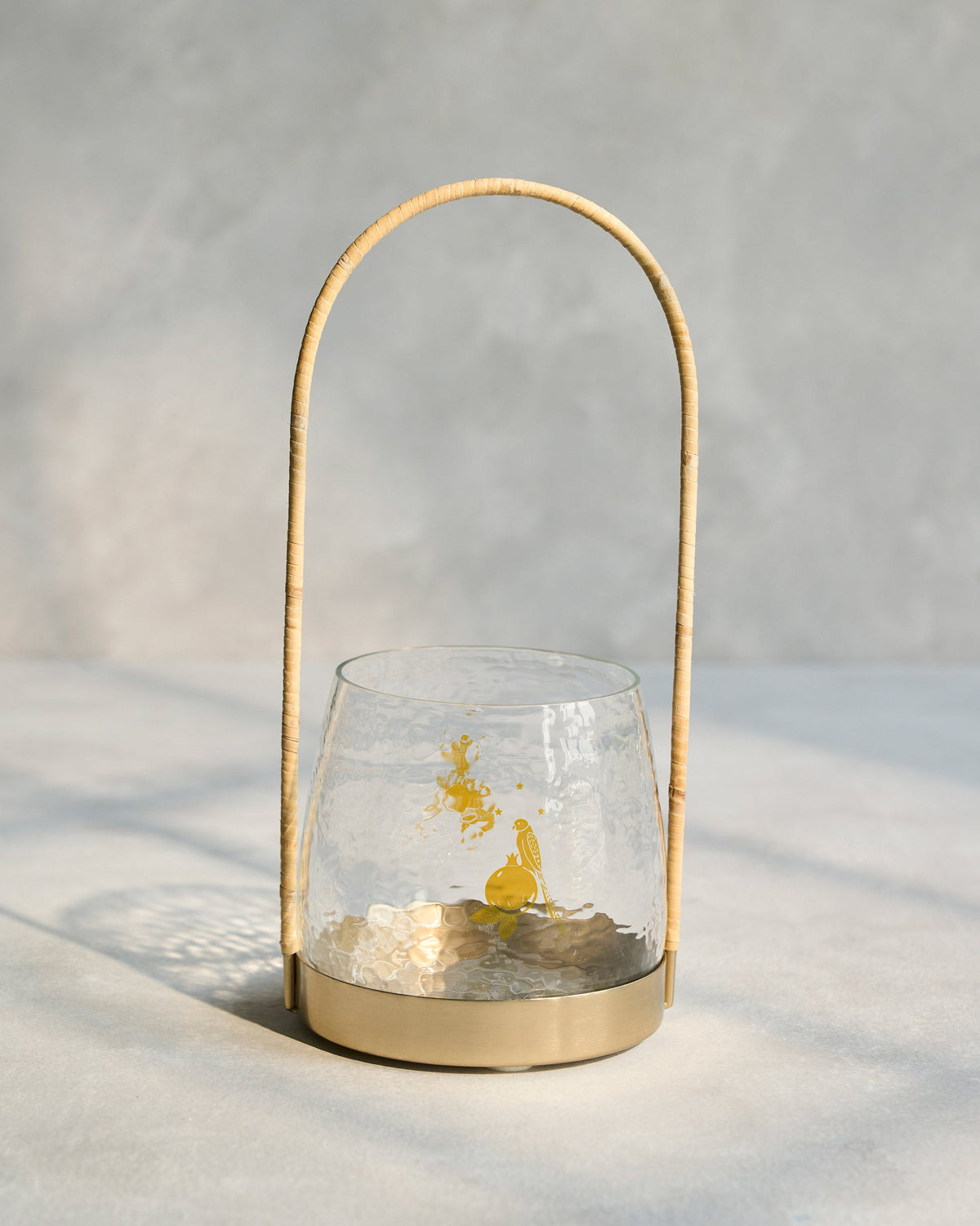 Vesak Lantern with a rattan handle, brass base and yellow motif on the glass.