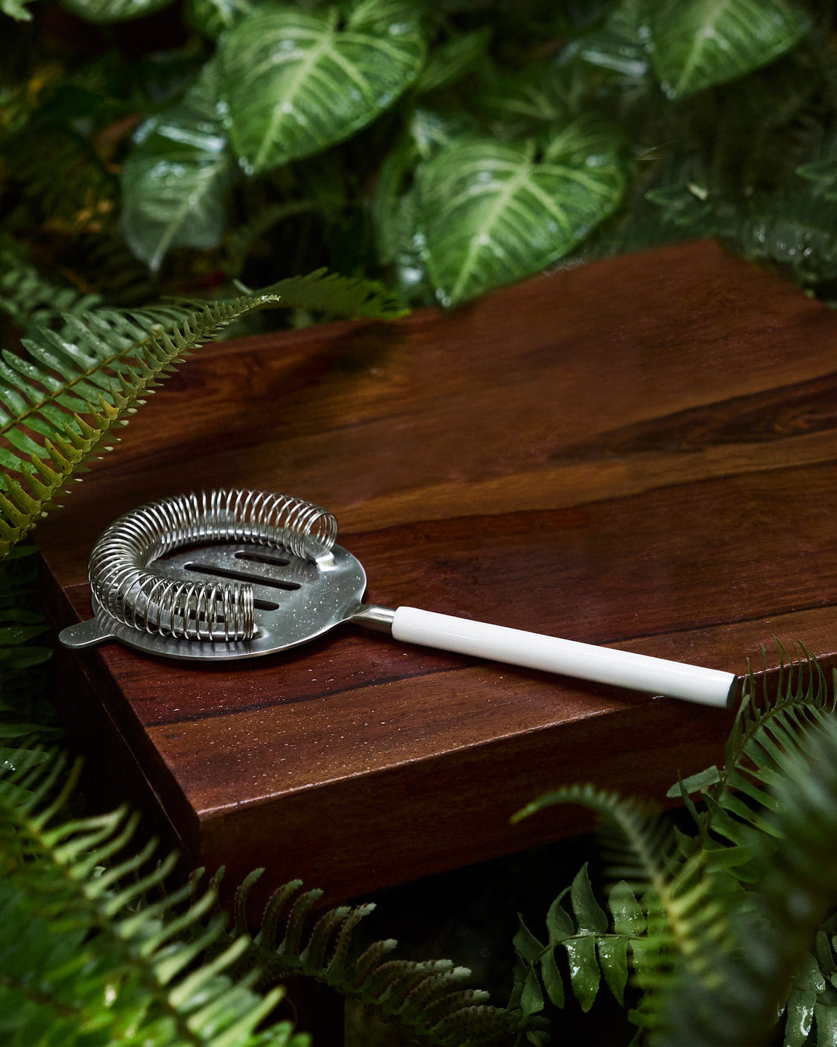 Riverside Cocktail Strainer -White with a white handle on a wooden board.