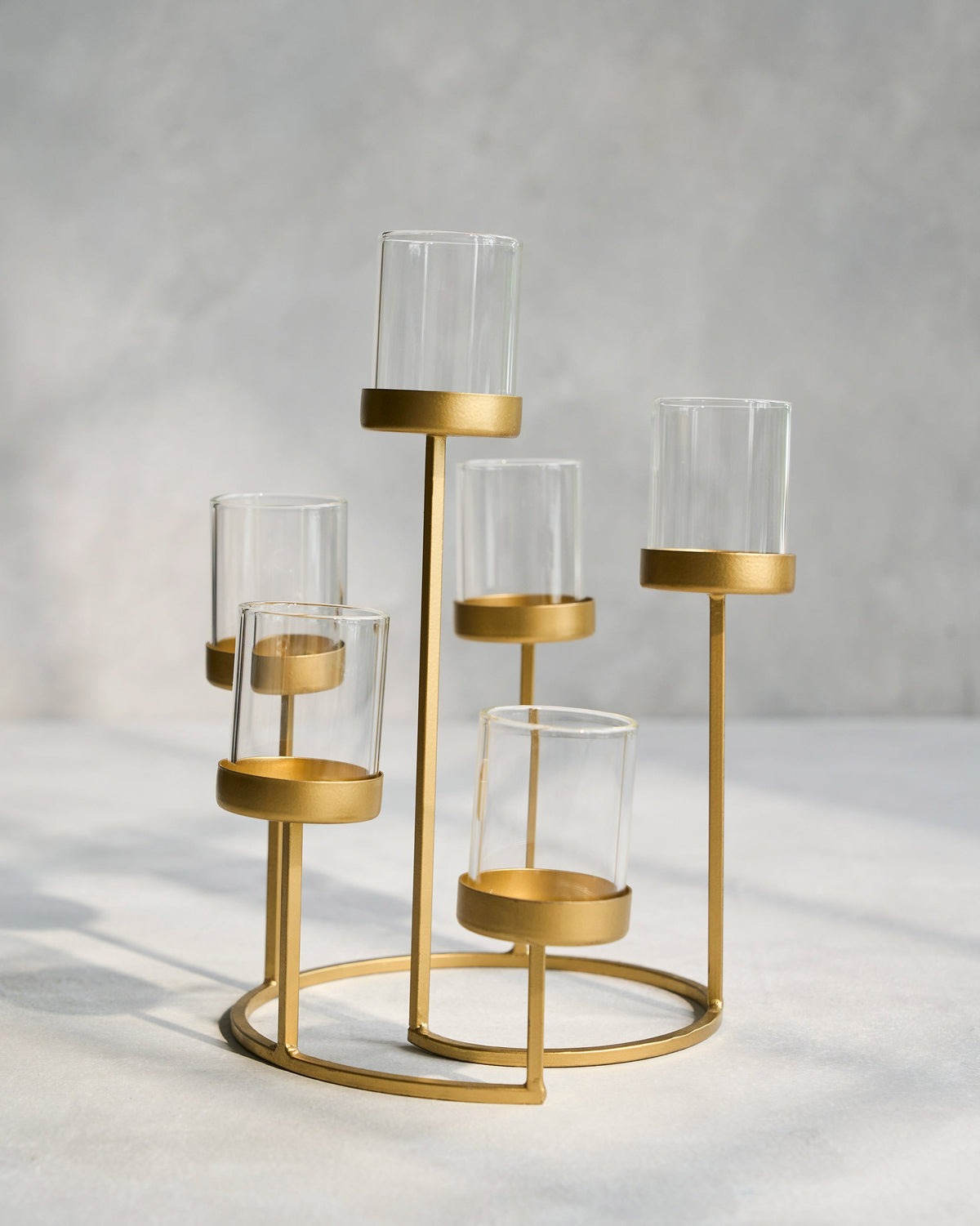 Float Votives gold stand with glass cups at different heights.
