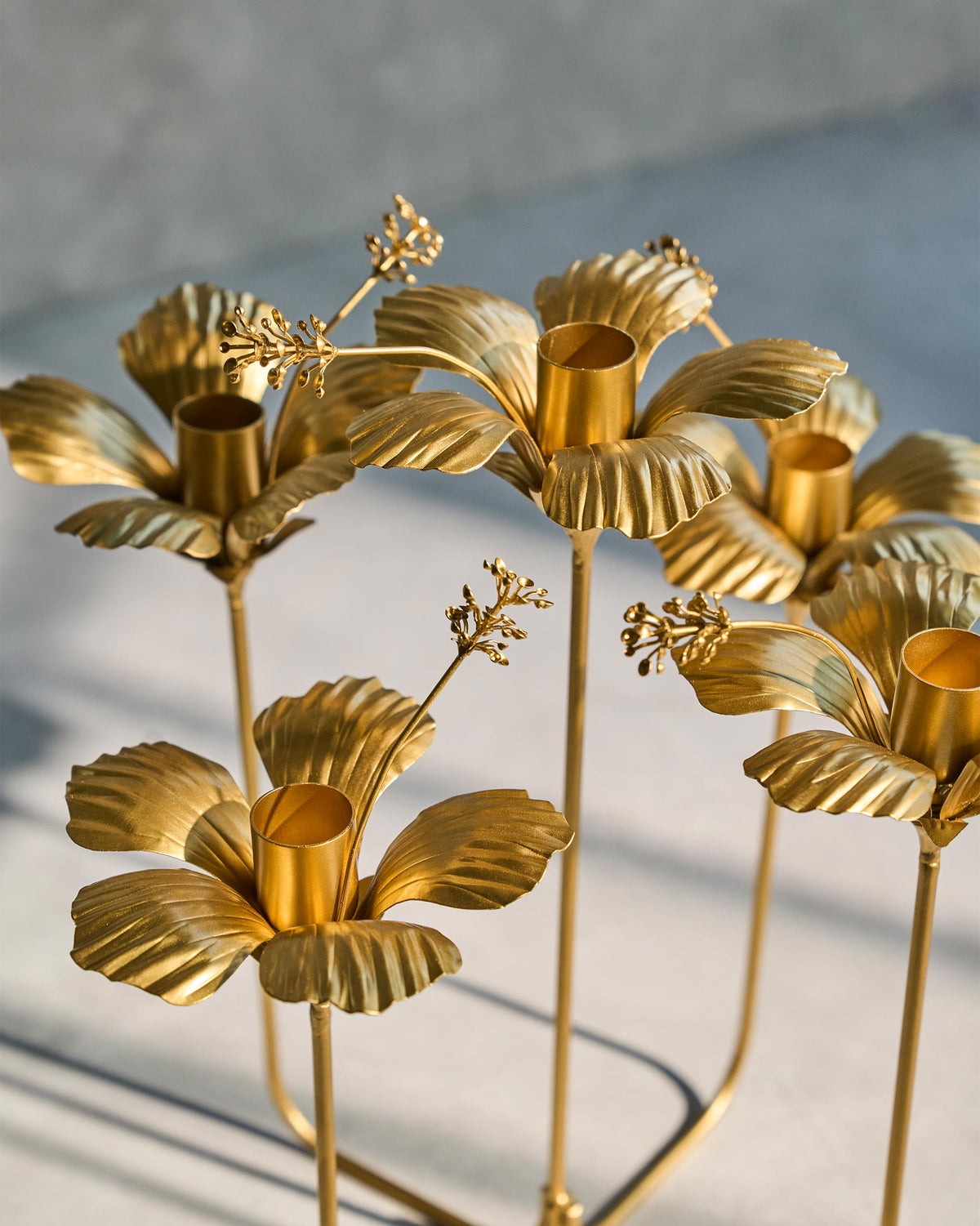 Close-up of gold hibiscus flowers on a candle holder.