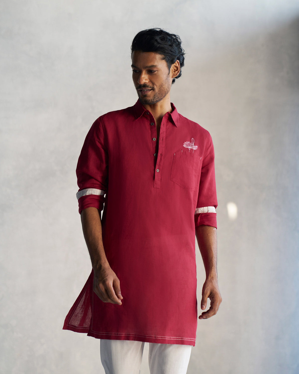 Person wearing a red Garnet Kurta with white-lined rolled sleeves.