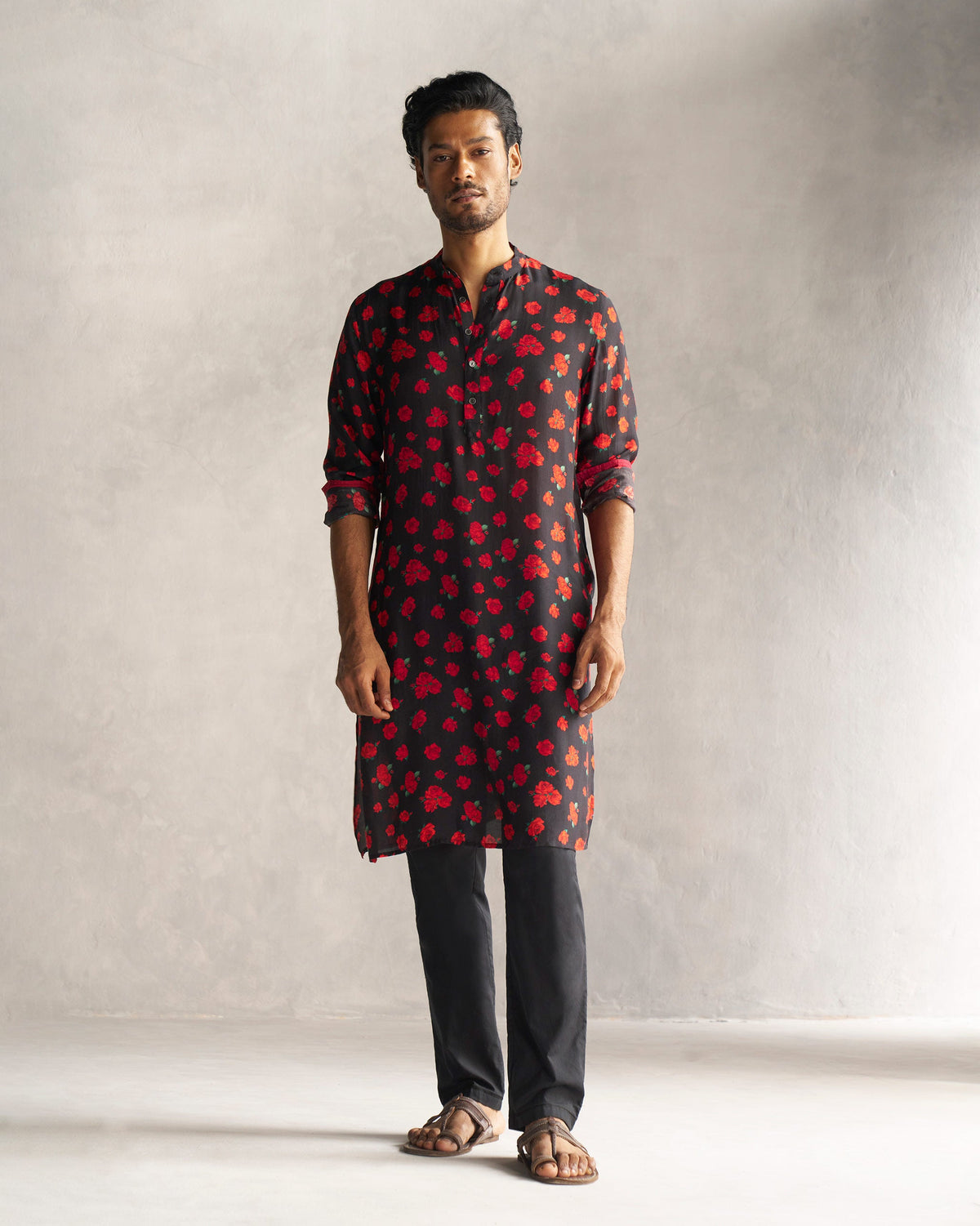 Person wearing a black Bageecha Kurta with a red rose print.
