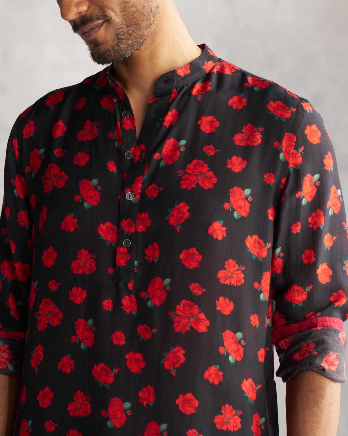 Close-up of a black Bageecha Kurta showing its red rose print and button placket.