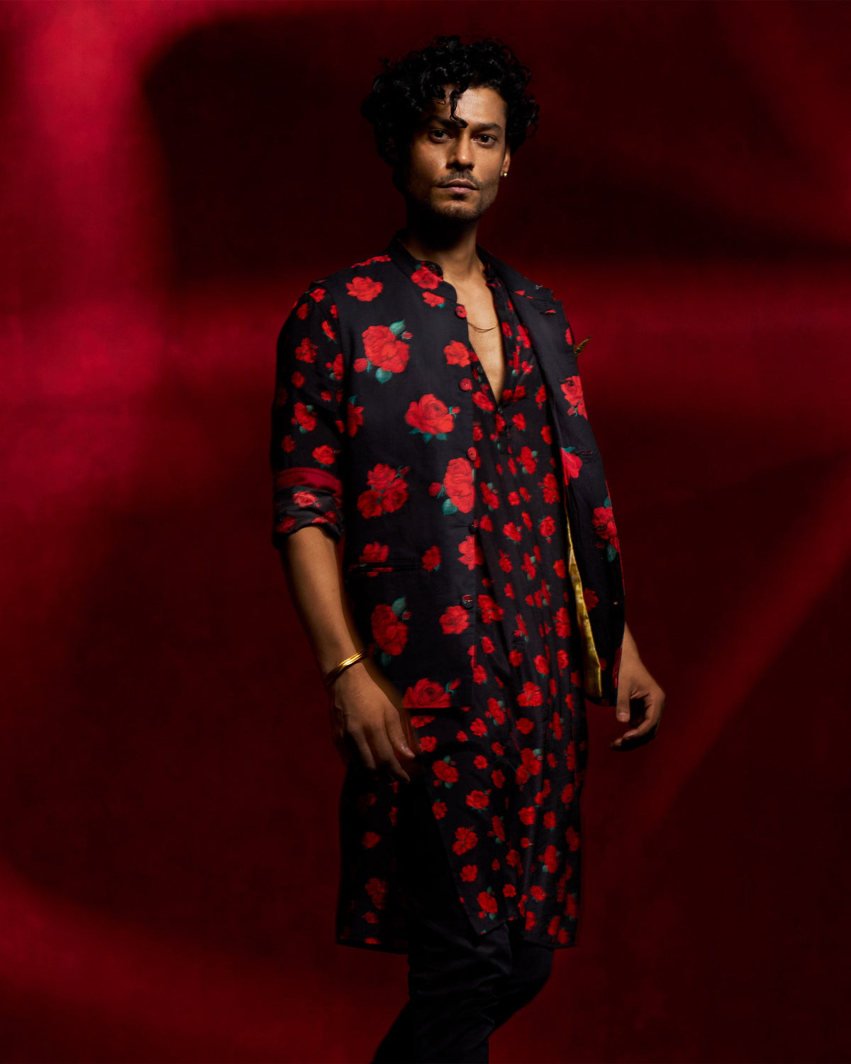 Person wearing a black Bageecha Kurta with a red rose print, angled to the side.