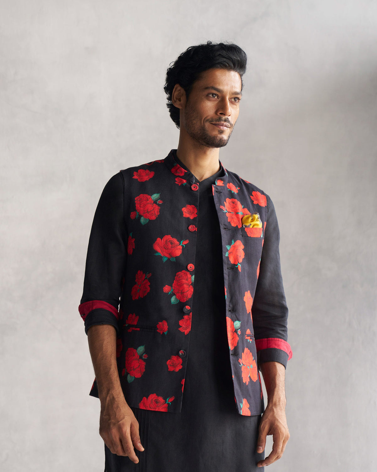Half-turned view of a black Nehru Jacket with red rose print.