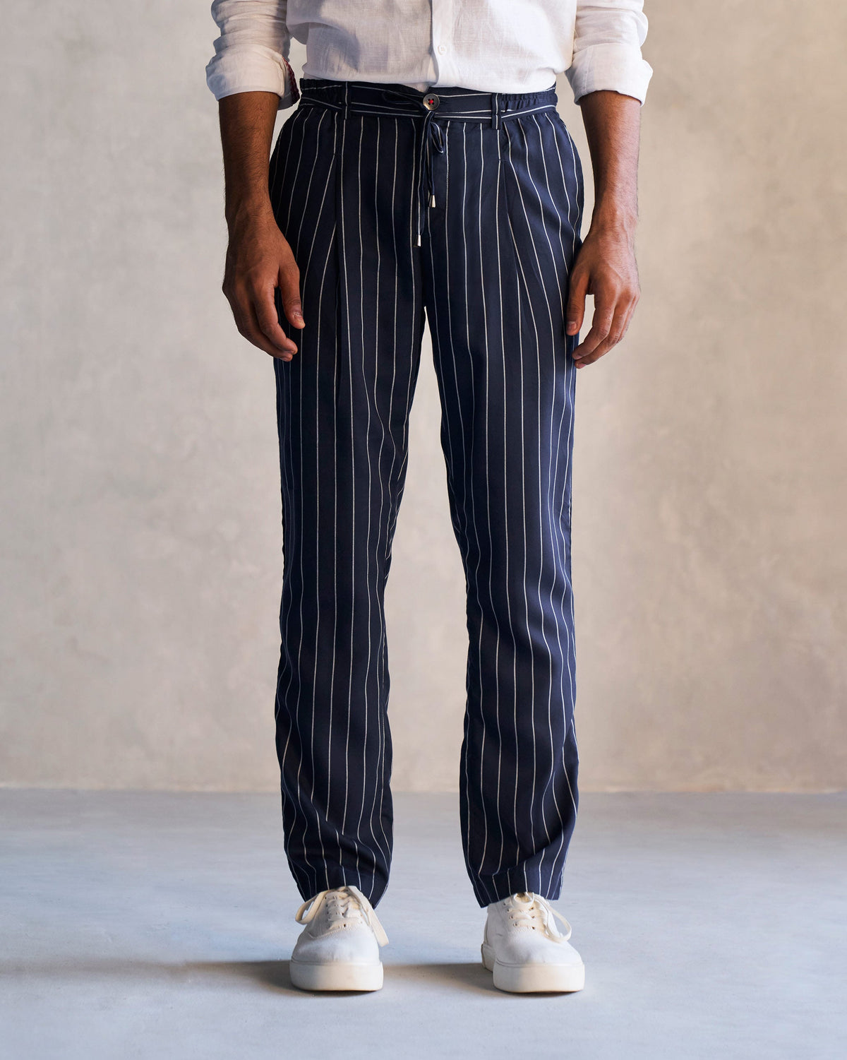 Person wearing navy Banjara Trousers with white pinstripes.