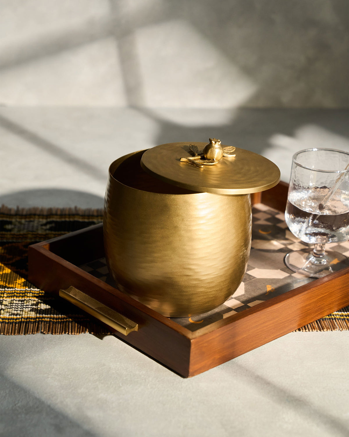 Anar ice bucket with a gold lid, placed on a wooden tray.