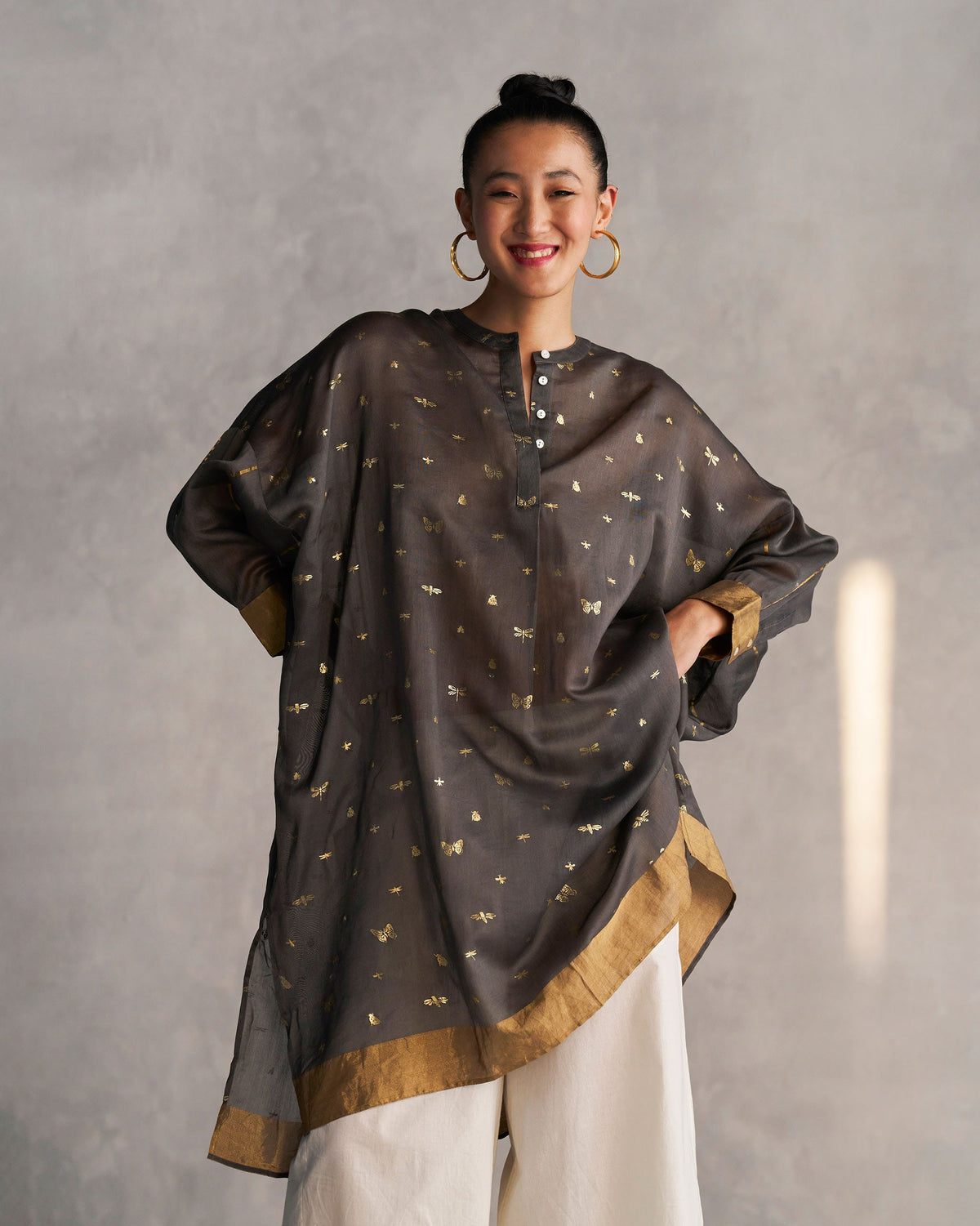 Person wearing a charcoal Lazy Saturday Tunic with a band collar and buttons.