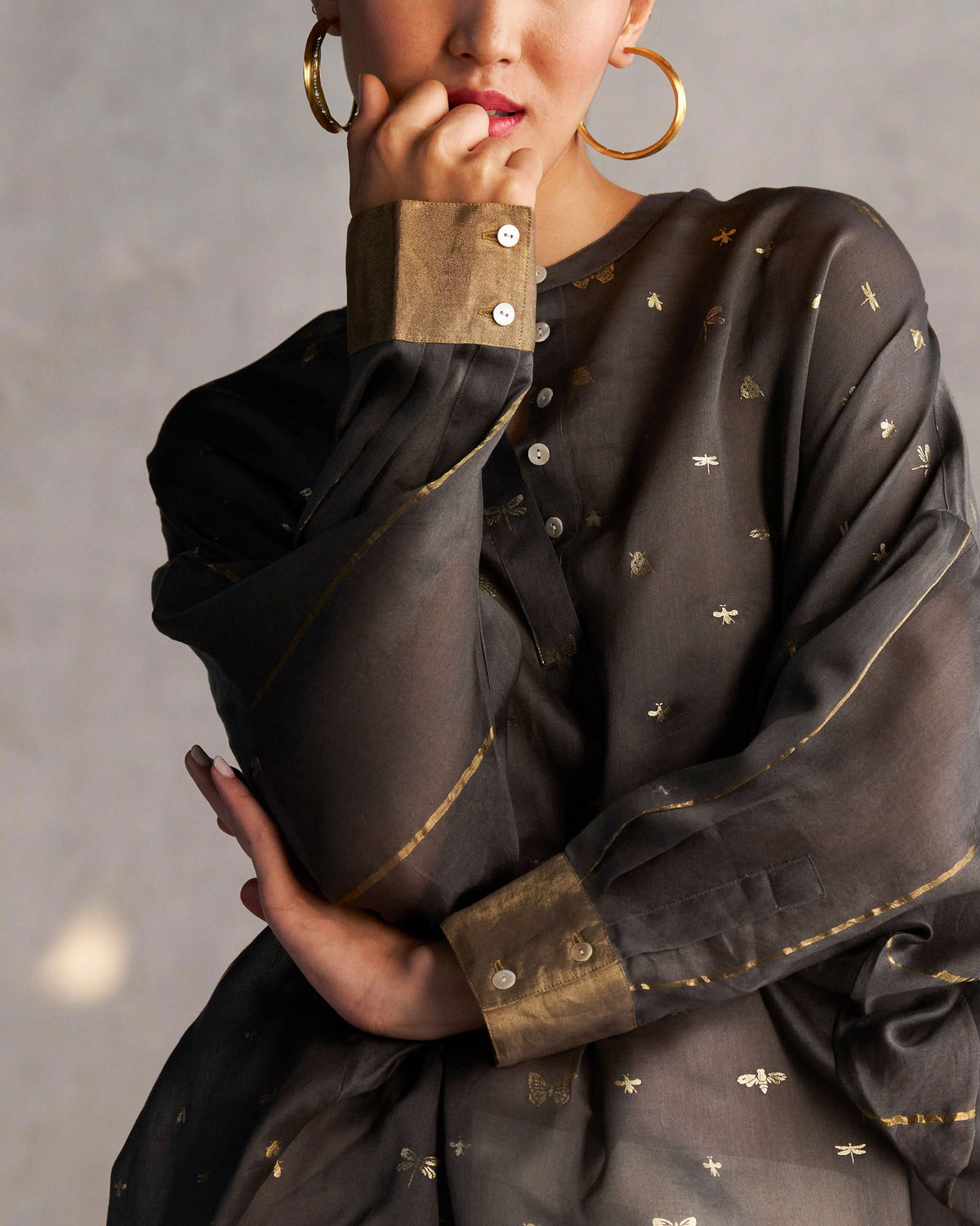 Close-up of a Lazy Saturday Tunic showing gold cuffs and gold-printed motifs.