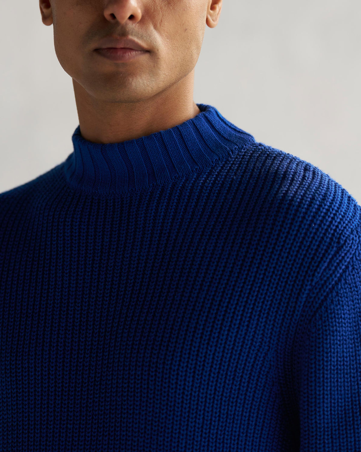Close-up of a blue Coast sweater mock neck in ribbed knit.