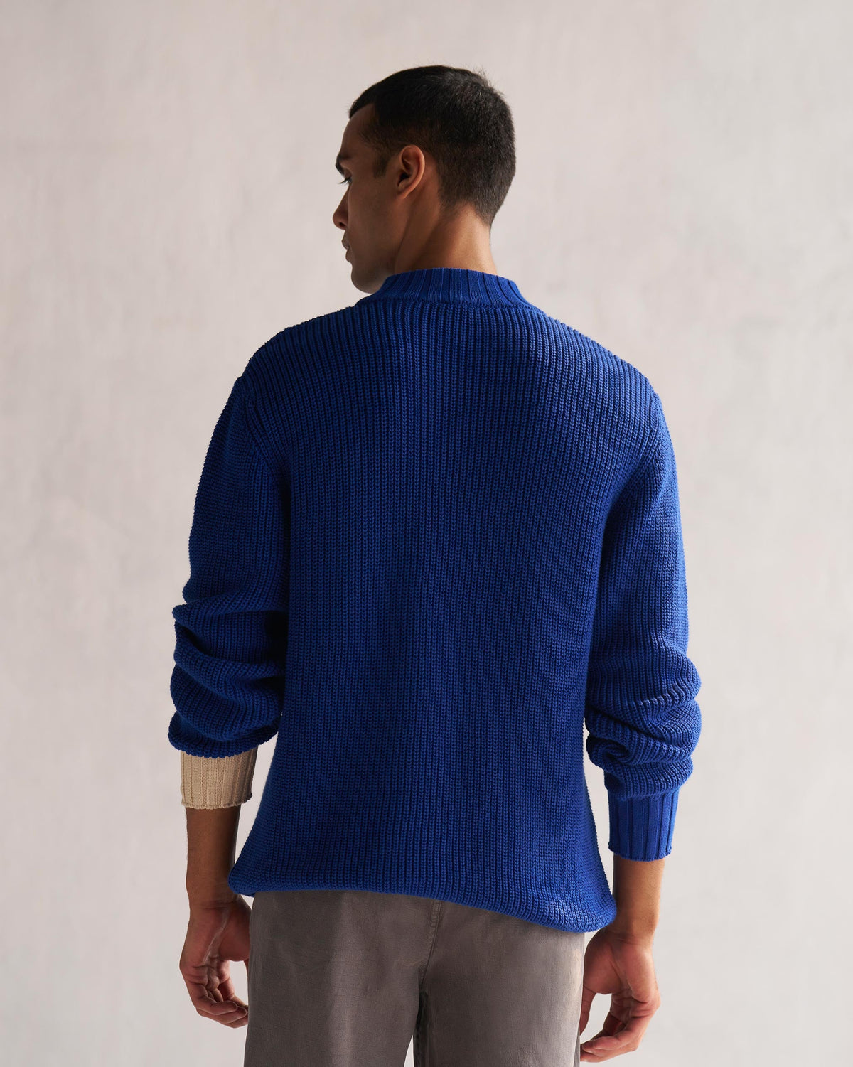 Back of a blue Coast sweater worn by a person.