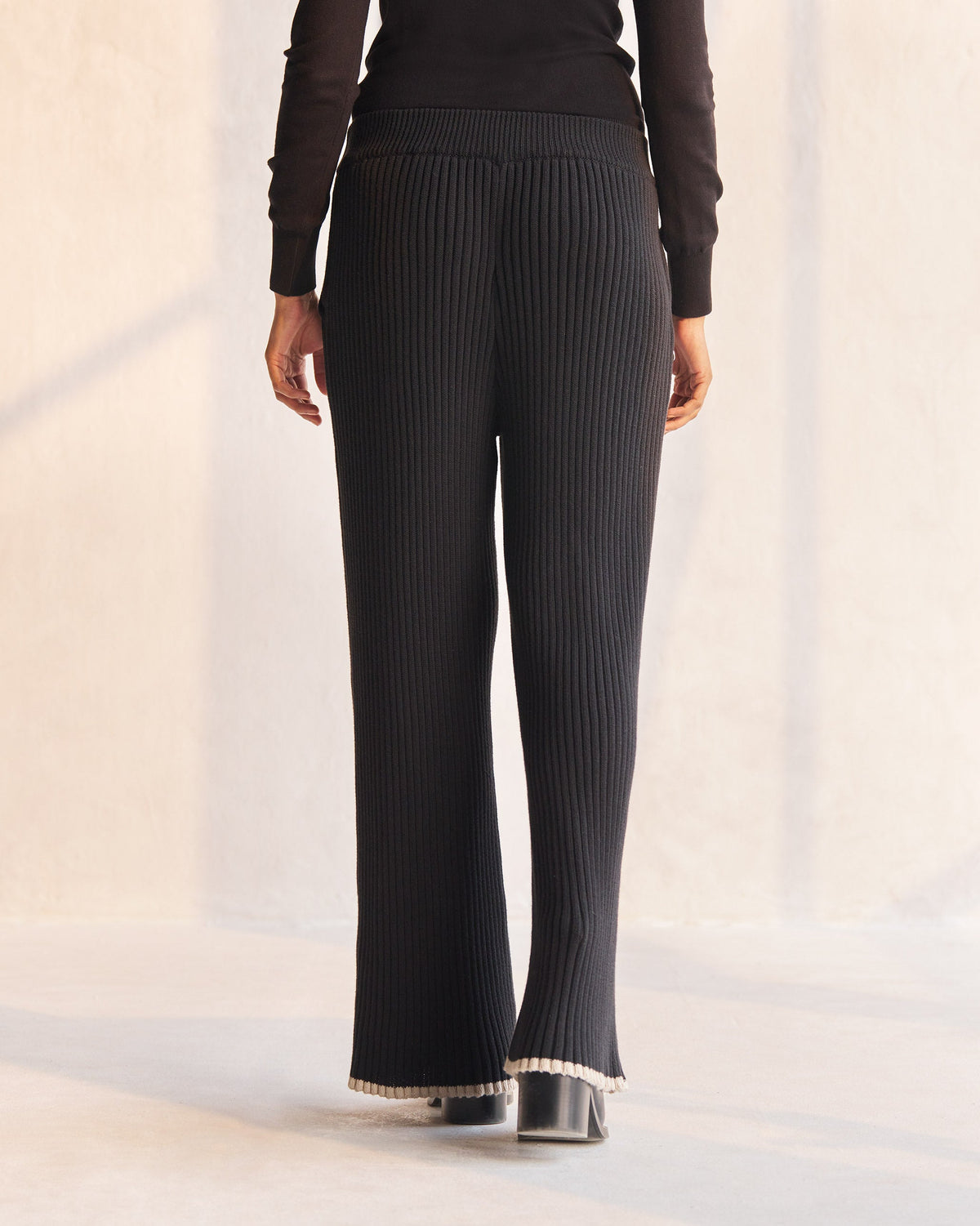 Back of black Ribbed Knit Trousers worn by a person.