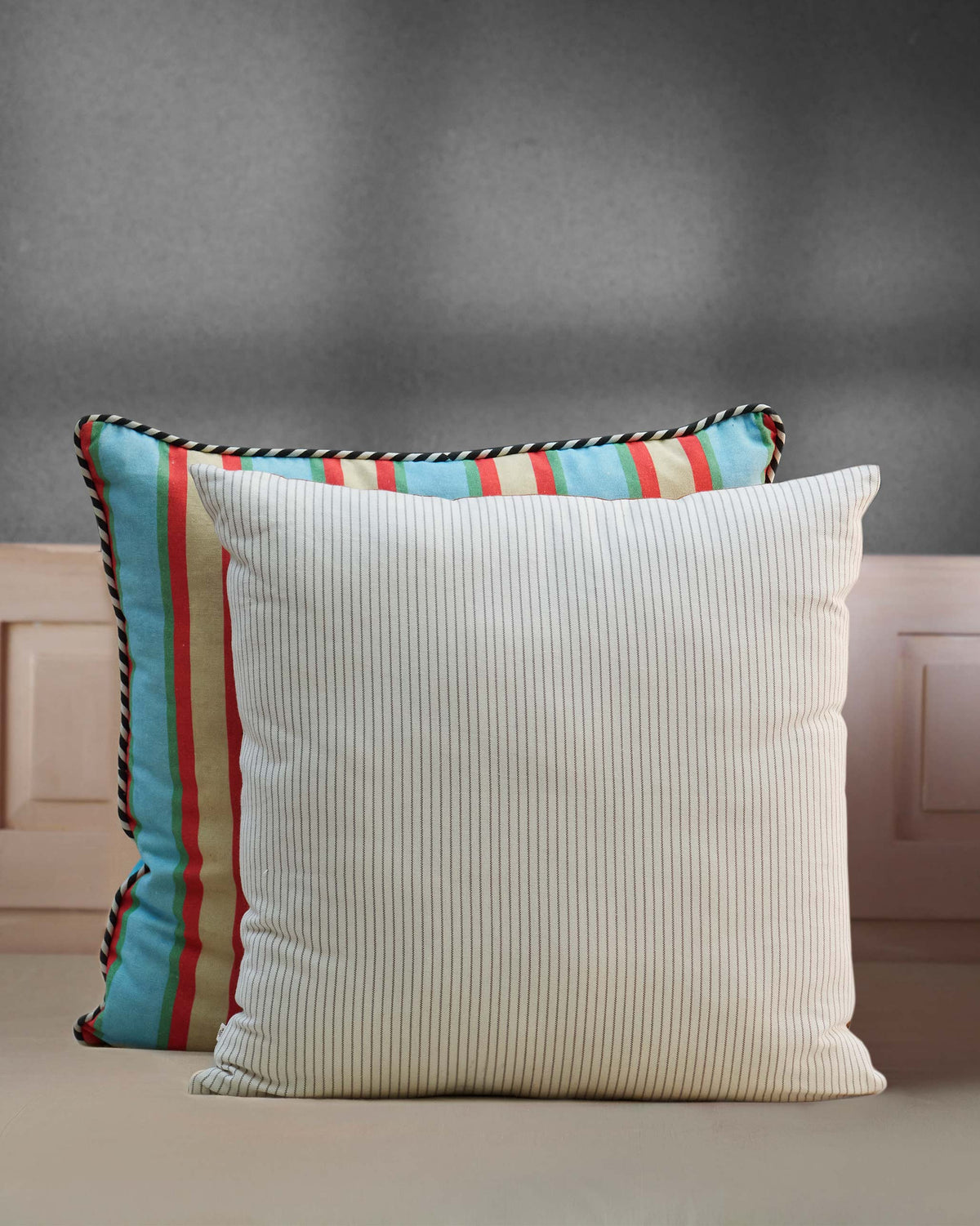 Rajasri Cushion Cover in cream with fine pinstripes, set against a striped cushion.