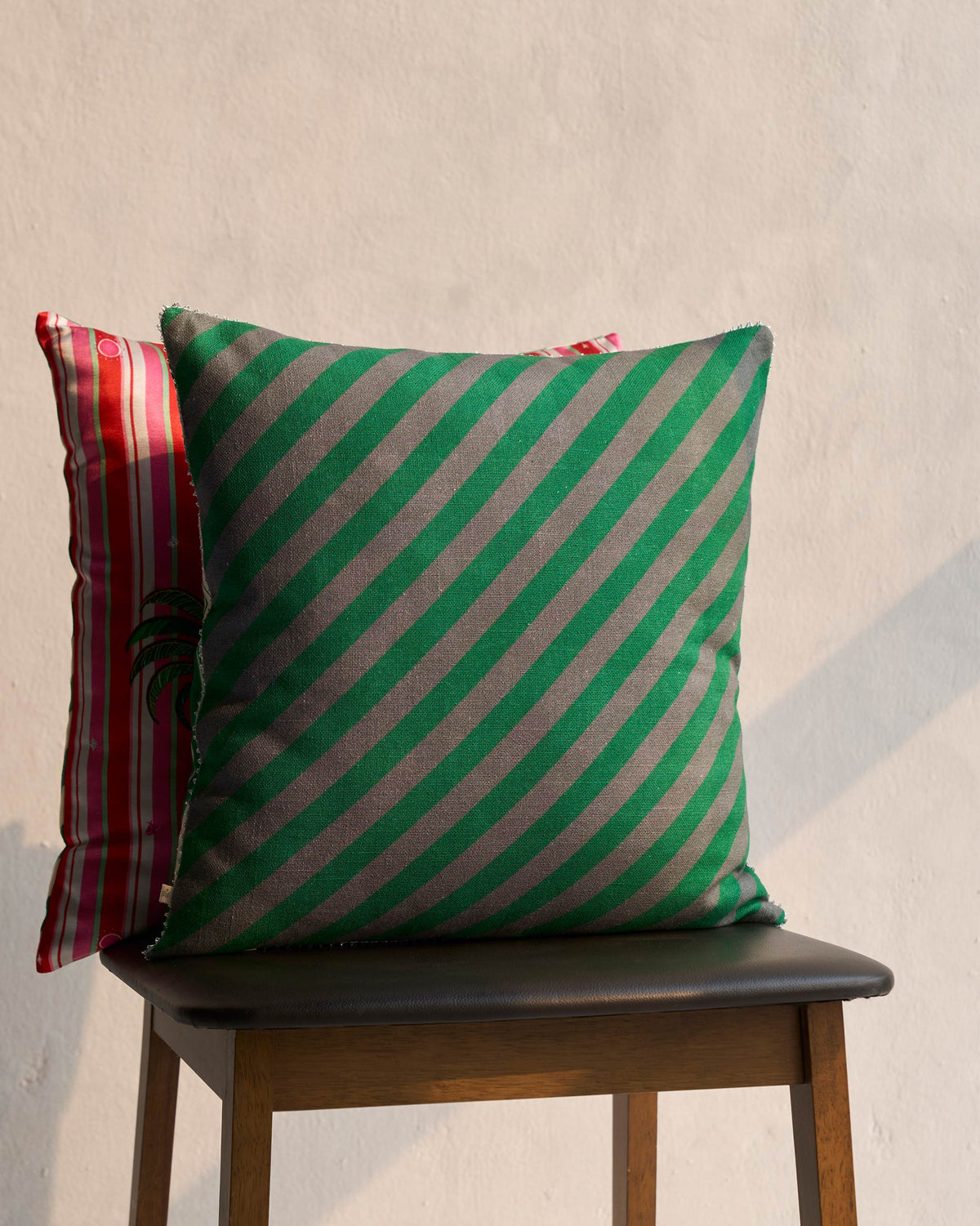 Bud Cushion Cover in a diagonal green and grey stripe.