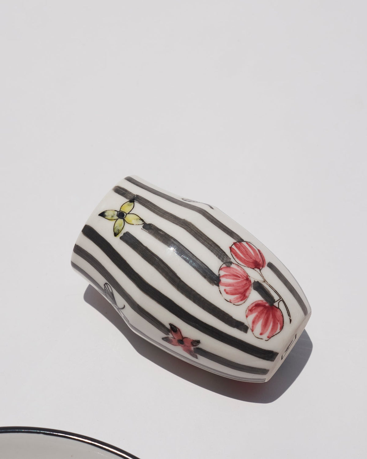 Close-up of a striped cup from the Just Juice It gift set showing painted pink flowers.