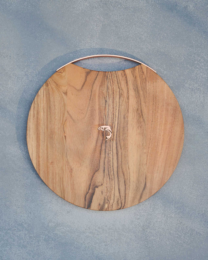 Garden Round Grazing Board with a curved copper-toned handle and fish motif.