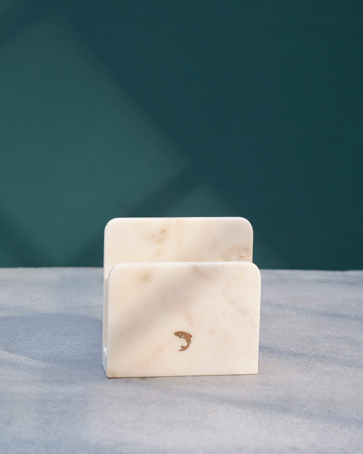 Close-up of the fish motif inlaid on the white marble Napkin Holder.
