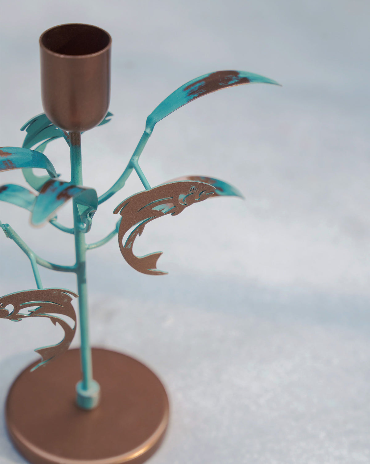 Close-up of the Pacific Candle Stand showing copper fish and teal leaves.