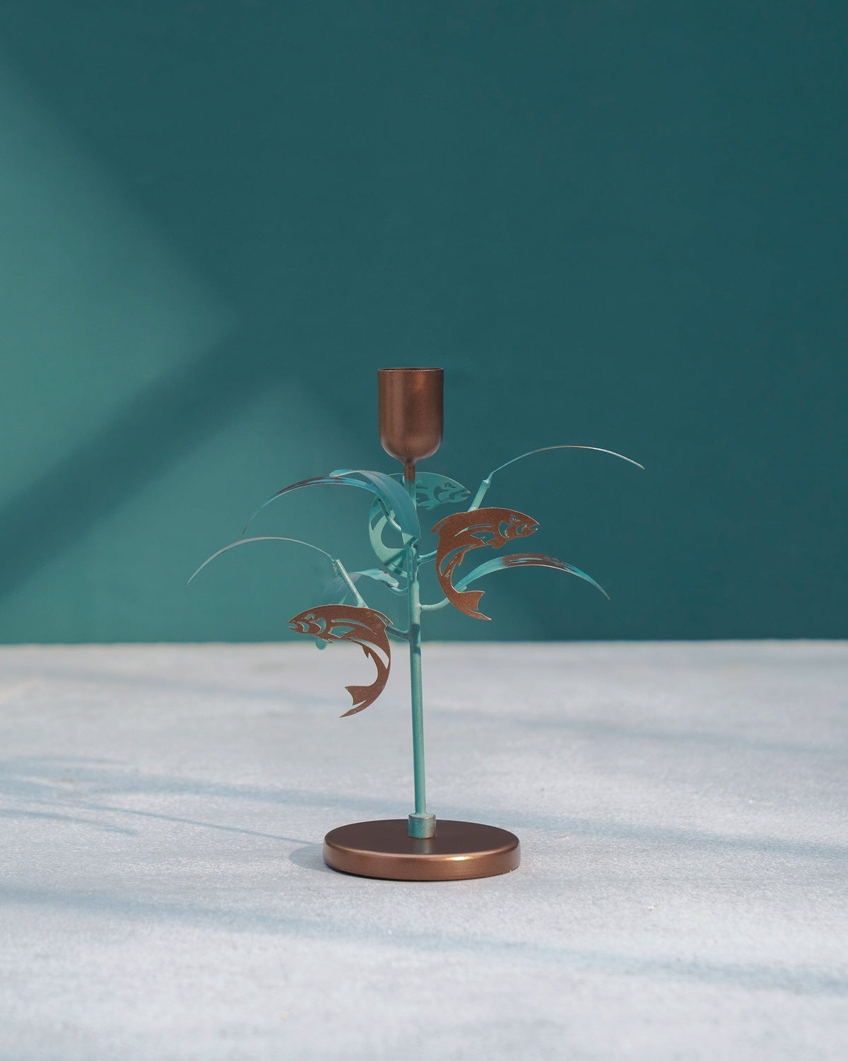Pacific Candle Stand seen from the front, with its copper fish motifs.