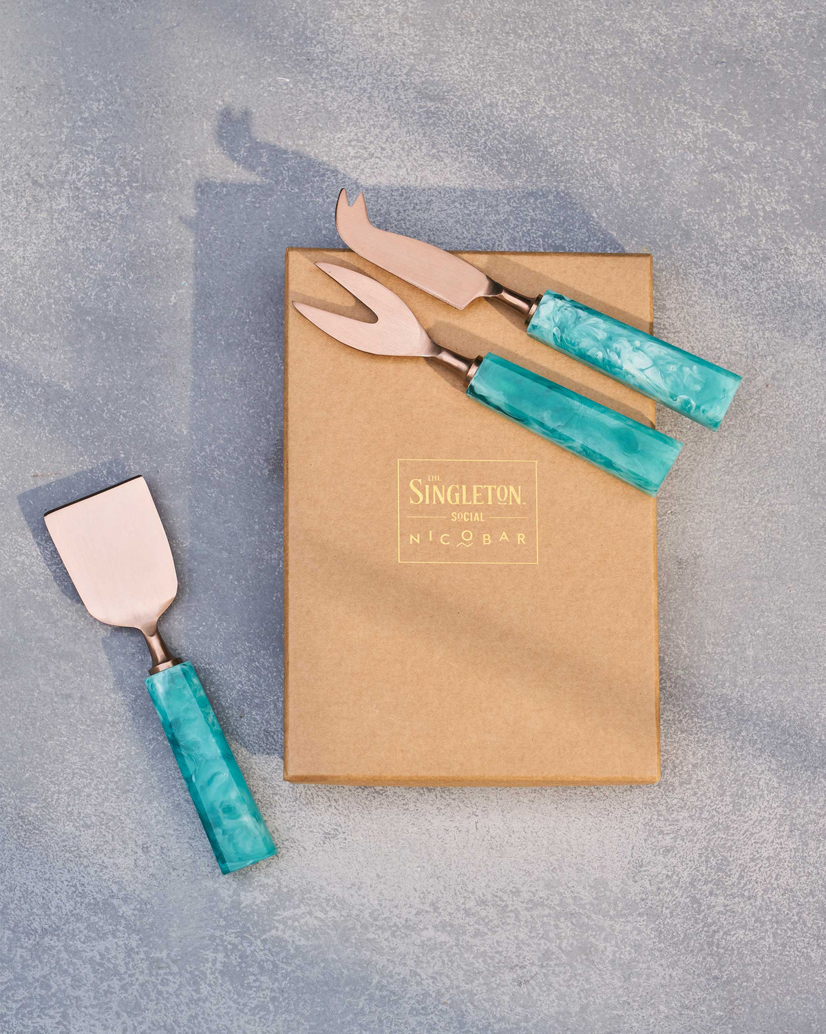 Teal Knife (Set of 3) laid across a kraft box with gold branding.