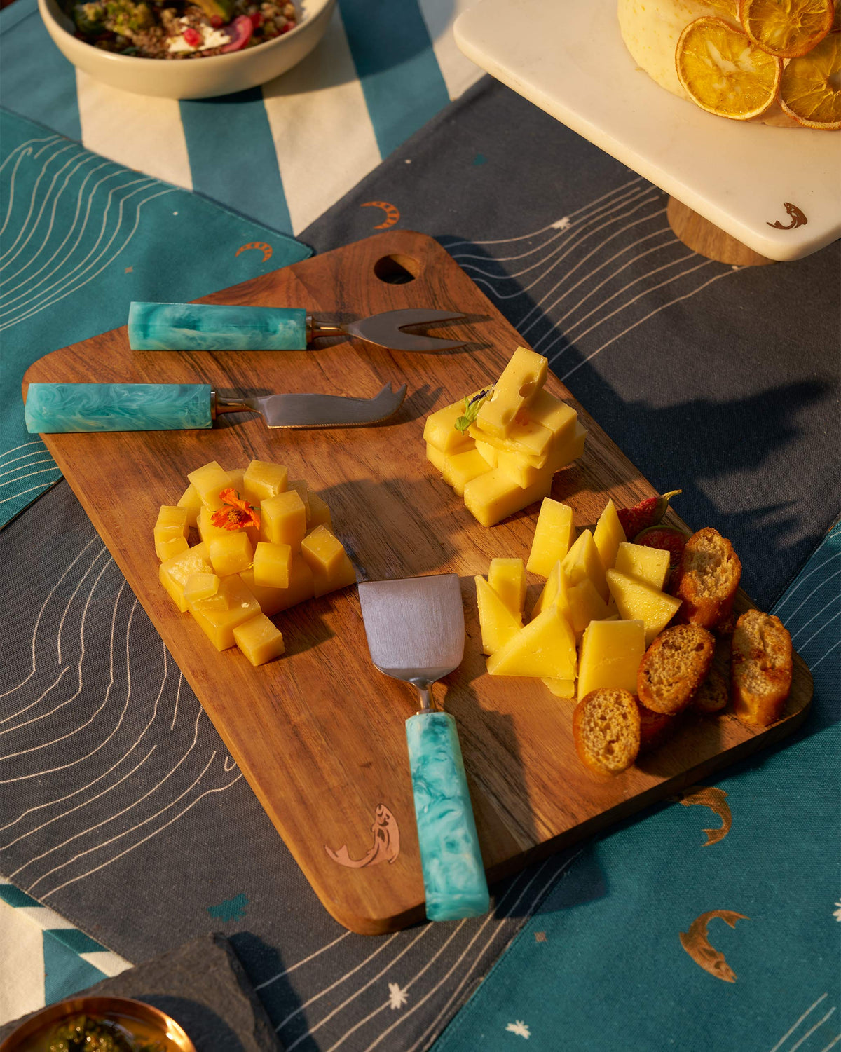 Teal Knife (Set of 3) in use, with its teal handles on a serving board.