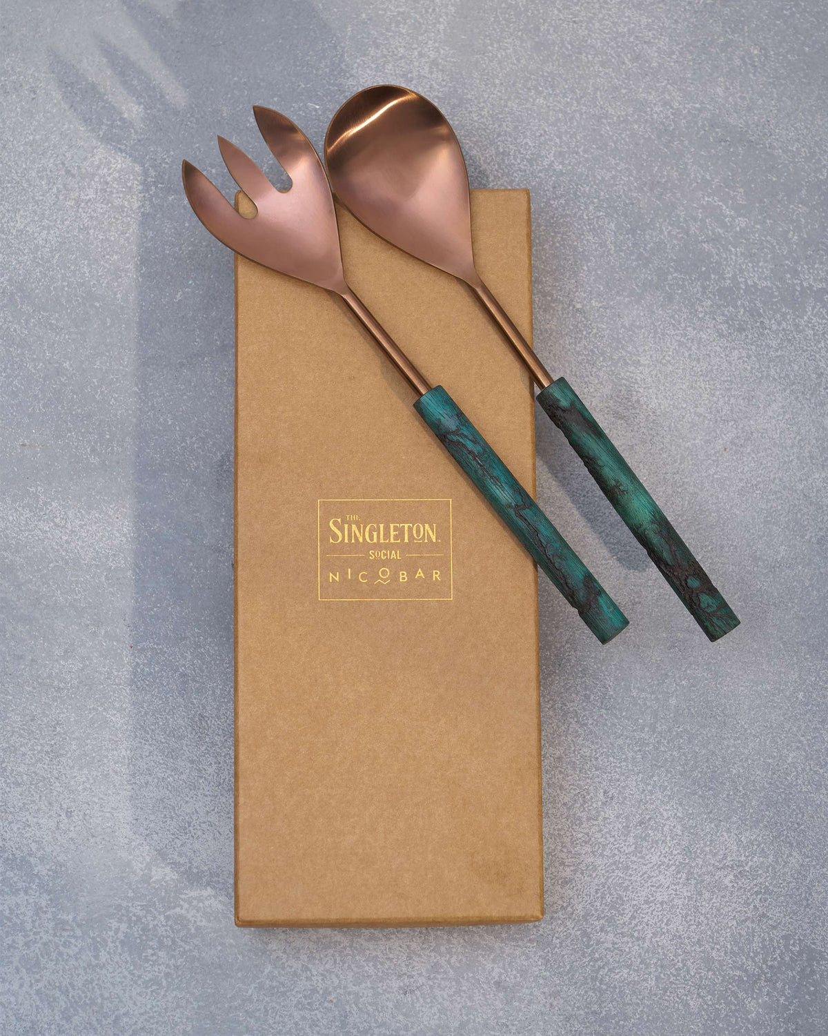Garden Salad Server spoon and fork resting on a kraft gift box.