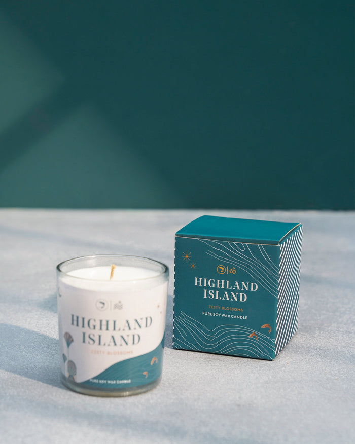 Shell Candle in a glass jar beside its teal gift box.