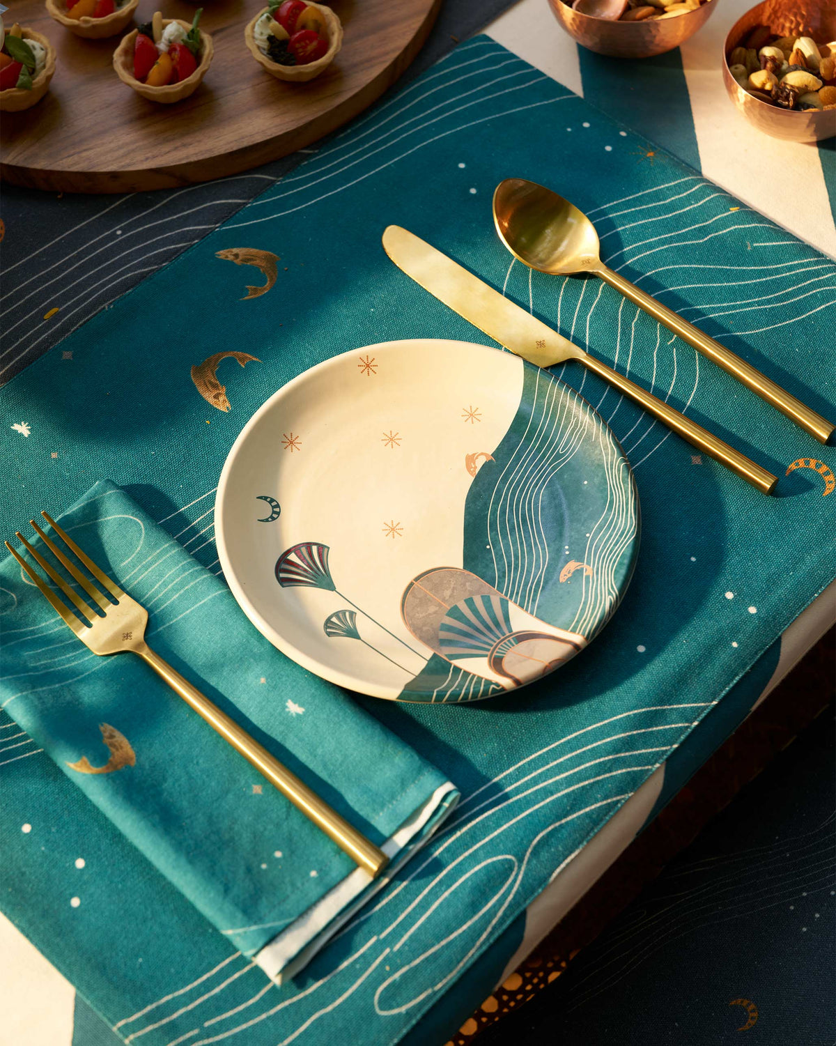 Tranquil Placemat in teal with white wave lines, set with a plate and cutlery.