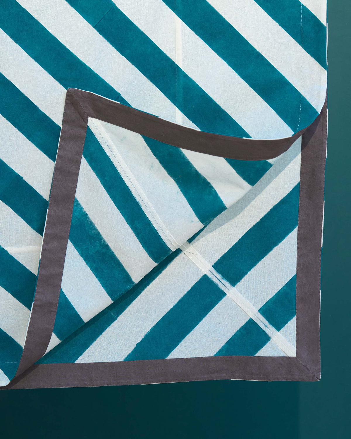 Close-up of the Plush Tablecloth folded corner with a grey border.