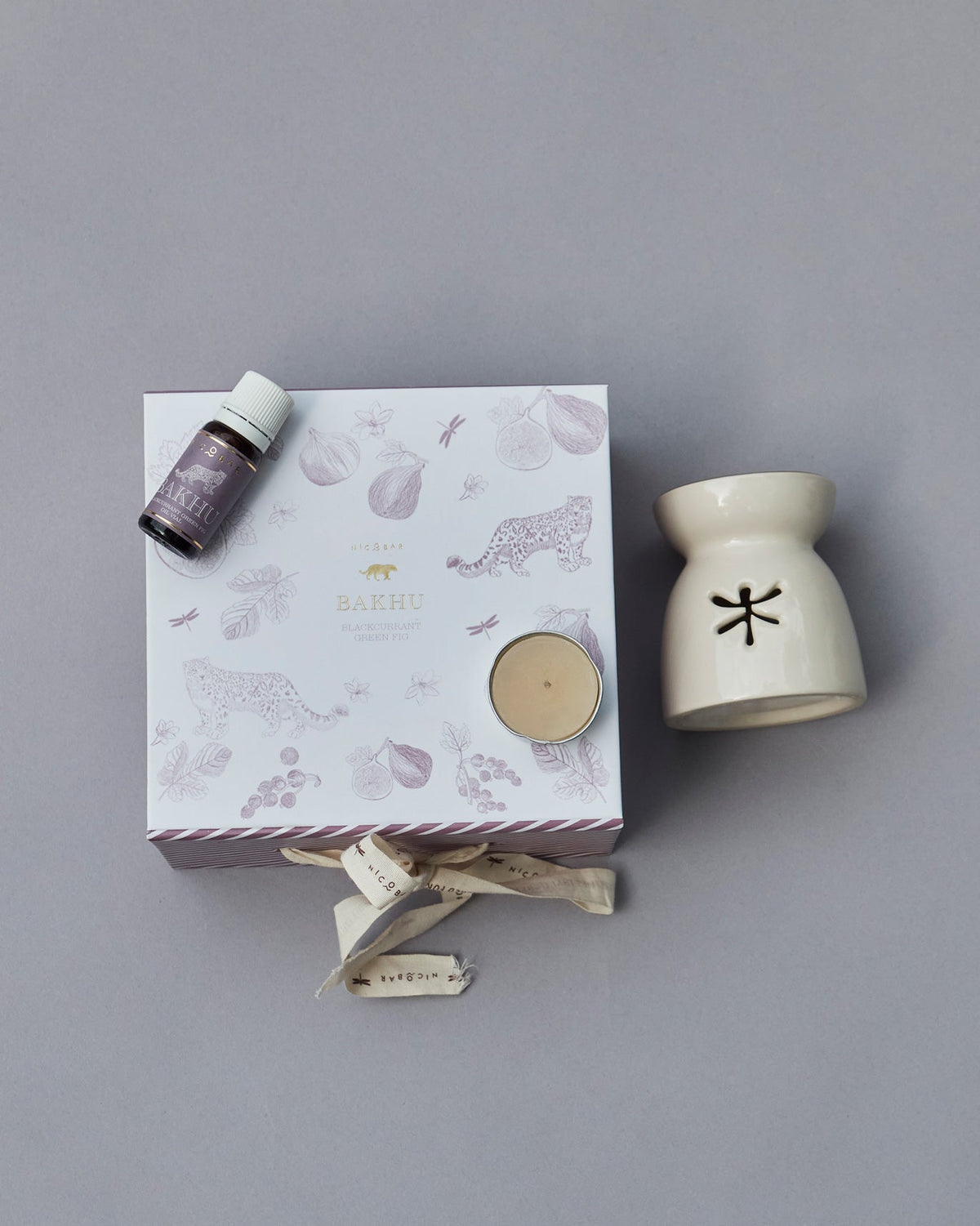 Sattva gift box and cream oil burner seen from above, with a bottle on the lid.