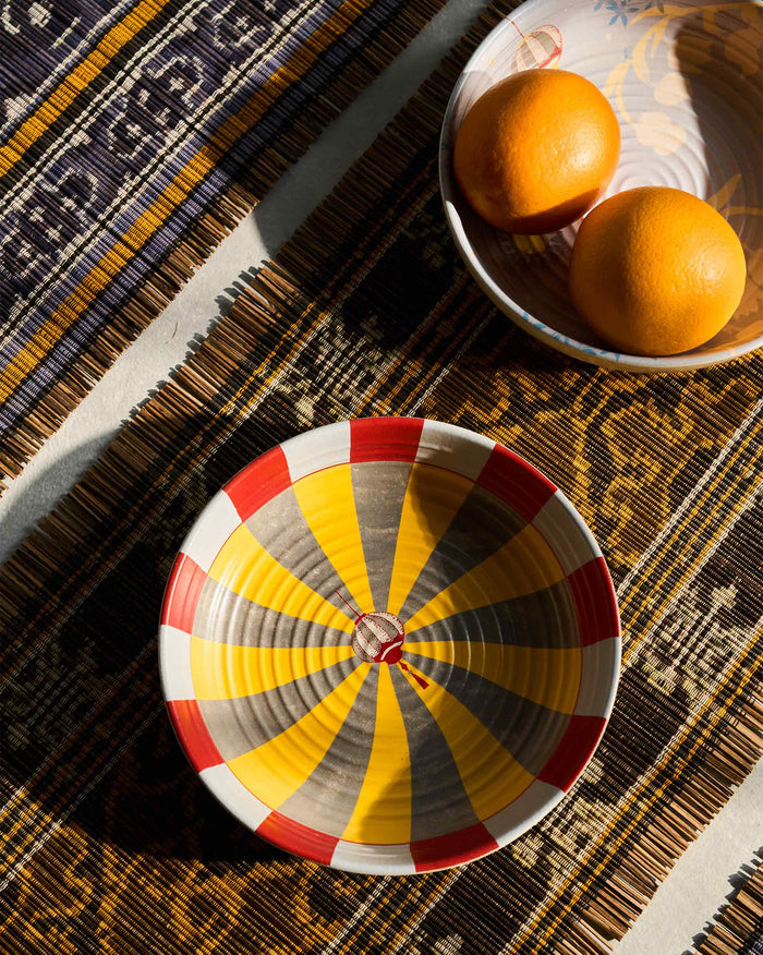 Chakra Shallow Bowl with radiating yellow and red stripes, seen from above.