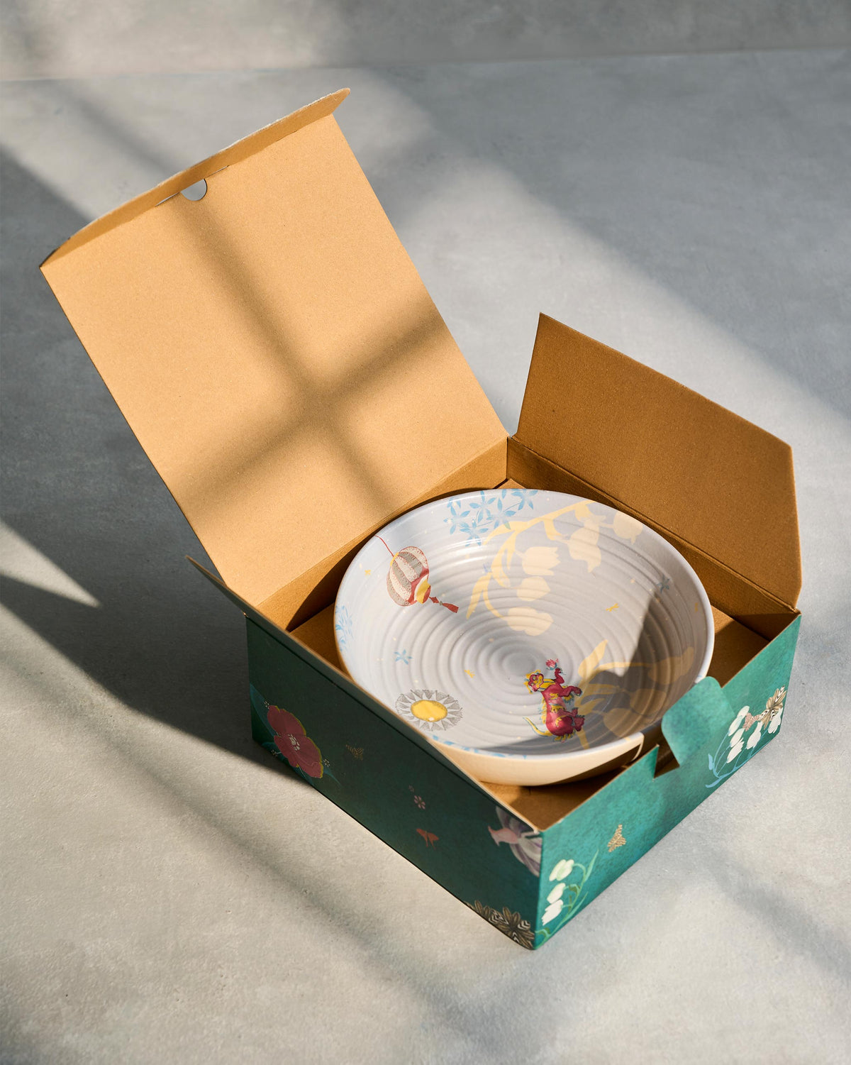 Painted Chakra Shallow Bowl inside an open Nicobar gift box.