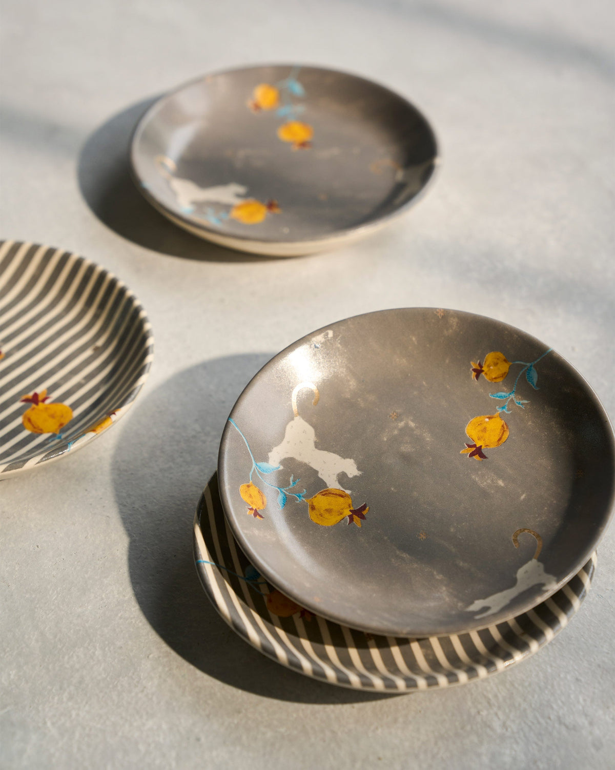 Close-up of a grey Anar tea plate showing pomegranate motifs.