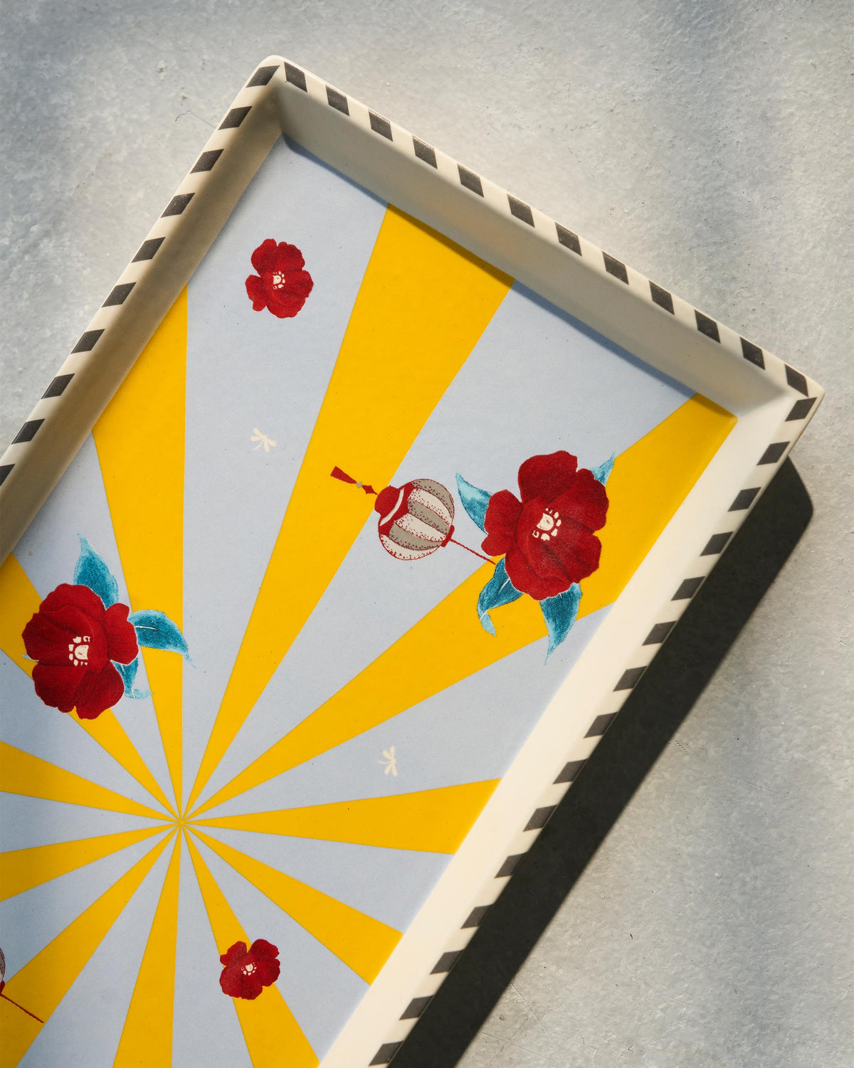 Close-up of Chakra Cookie Tray showing red flowers and lantern motifs on yellow rays.