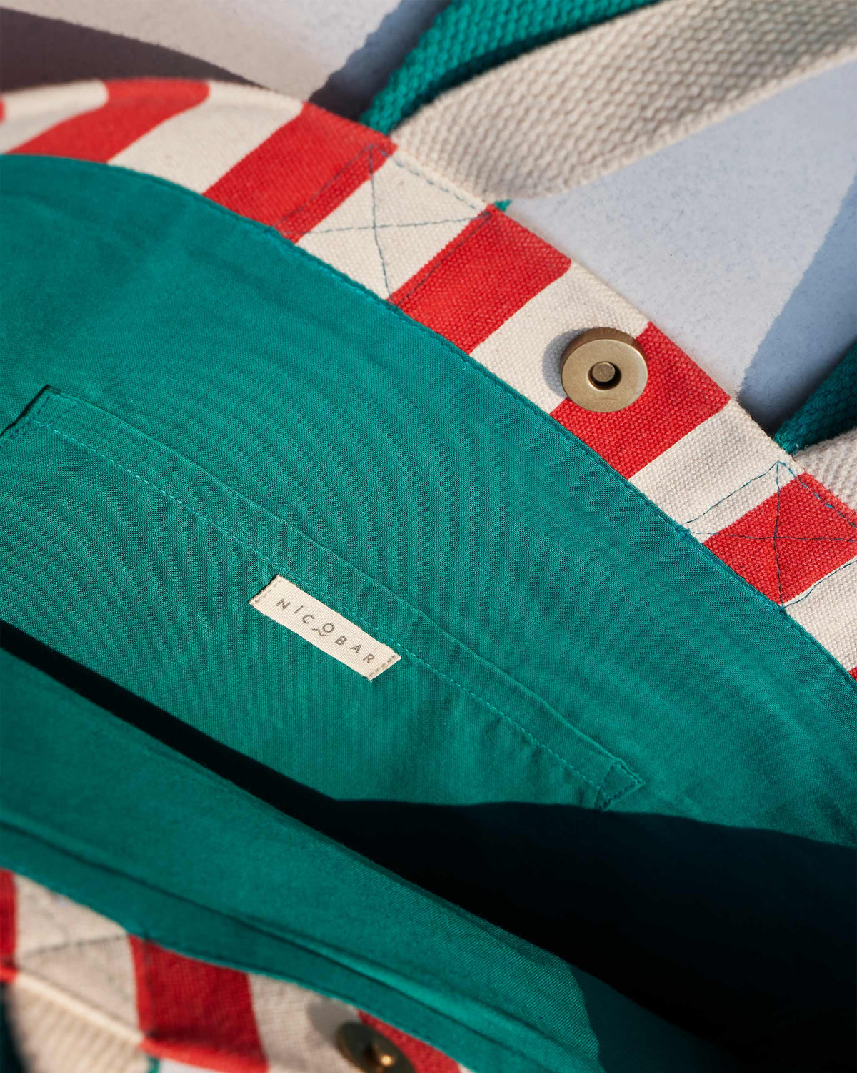 Close-up of the Bagan Stripe Tote interior with a teal pocket and Nicobar label.