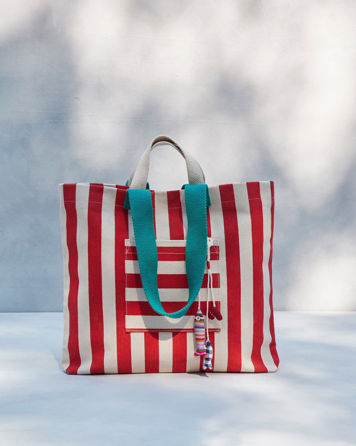 Bagan Stripe Tote standing upright with teal handles and a front pocket.