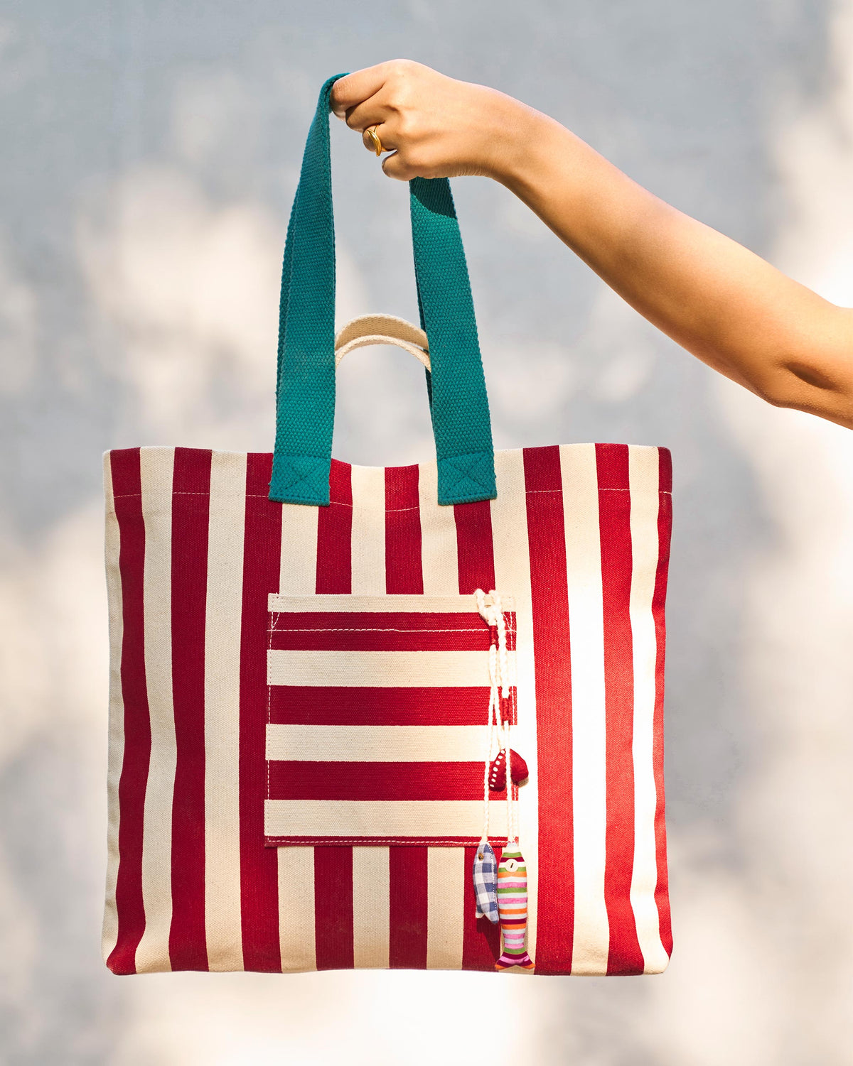 Person holding the Bagan Stripe Tote up by its handles.
