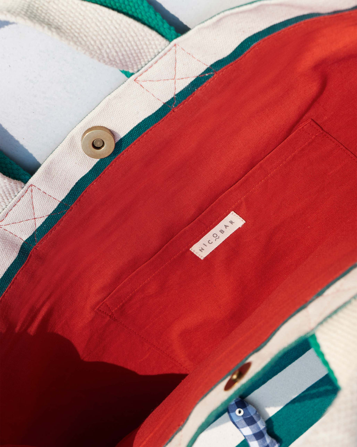Interior of a Bagan Stripe Tote with red lining and a Nicobar label.