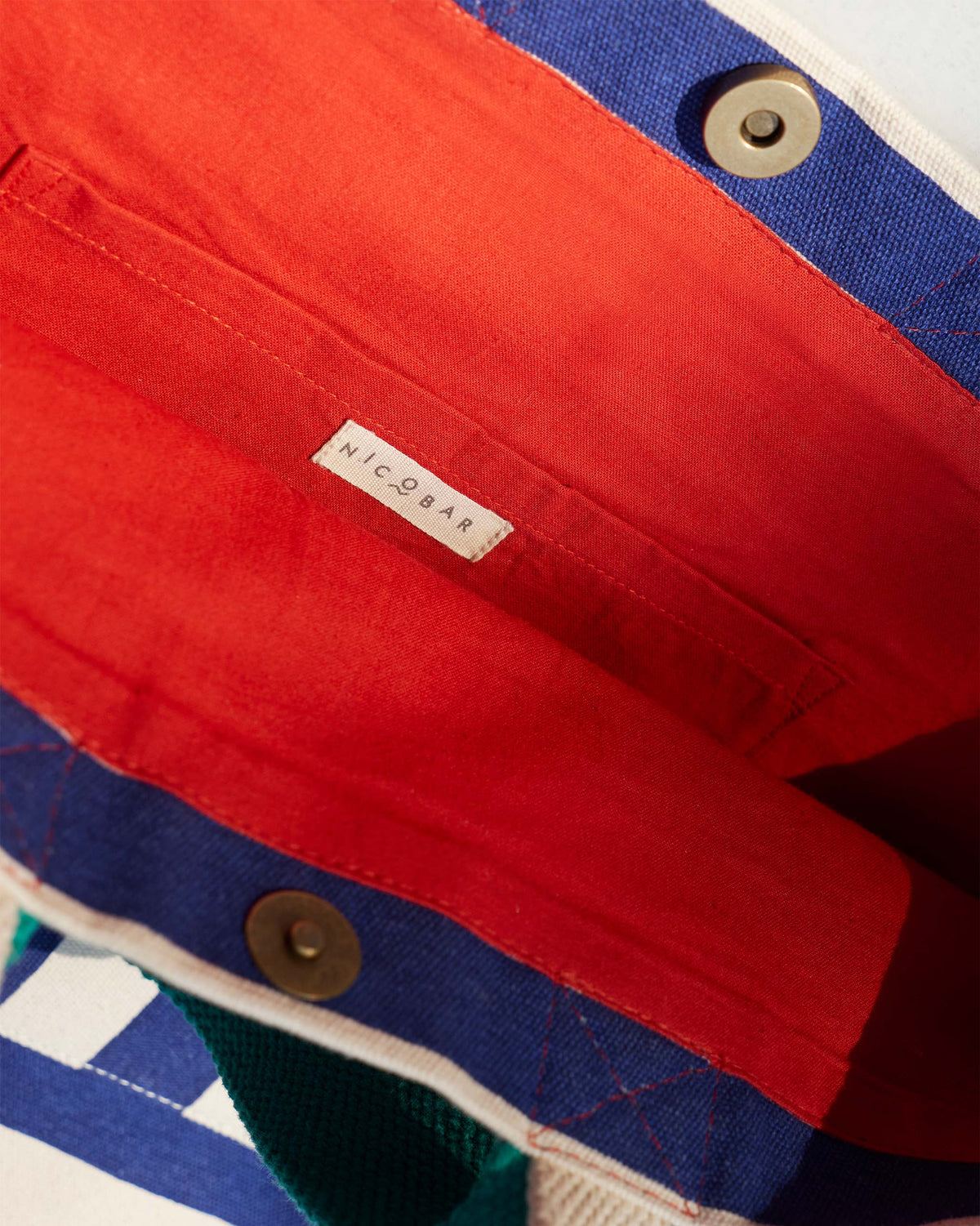 Interior of a Bagan Stripe Tote with red lining and a Nicobar label.