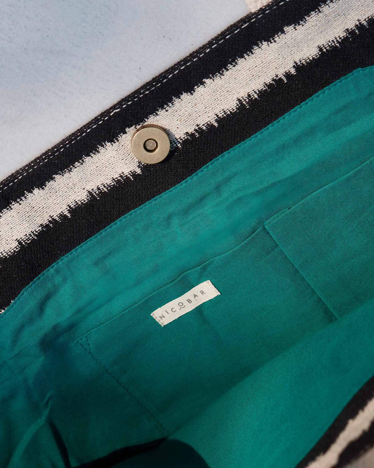 Interior of the Sunrise Stripe Tote with a green lining and Nicobar label.